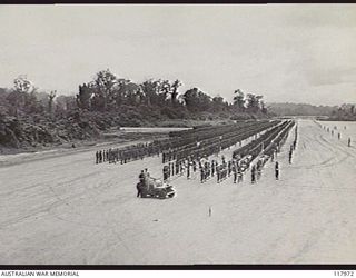 TOROKINA, BOUGAINVILLE. 1945-10-29. THE COMMANDER IN CHIEF, AUSTRALIAN MILITARY FORCES, IN HIS JEEP INSPECTING MEMBERS OF 3RD DIVISION DURING A GENERAL PARADE ON THE PIVA AIRSTRIP