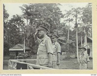 LAE AREA, NEW GUINEA. 1945-04-25. MAJOR-GENERAL C.H. SIMPSON, SIGNAL OFFICER- IN- CHIEF (1), TAKING THE SALUTE AT THE MARCH PAST OF 19 LINES OF COMMUNICATION SIGNALS DURING HIS TOUR OF INSPECTION ..