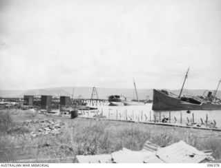 RABAUL, NEW BRITAIN, 1945-09-10. WRECKED JAPANESE VESSELS ARE NUMEROUS ALL ROUND SIMPSON HARBOUR, DESTROYED DURING ALLIED AIR ATTACKS. THIS PHOTOGRAPH SHOWS THE SCENE NEAR BURNS PHILP WHARF. TROOPS ..