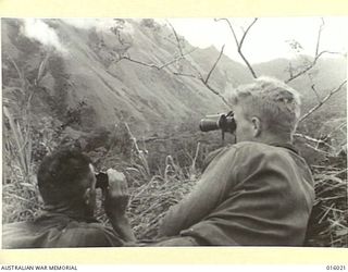 NEW GUINEA. UPPER RAMU VALLEY ADVANCE. A FORWARD POST IN THE RAMU VALLEY. LIEUT. R. MCFARLANE OF MELBOURNE AND PTE. T. RICHARDSON OF EAST GRESFORD, N.S.W. EXAMINE A VILLAGE FROM WHICH THE JAPS HAD ..