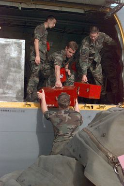 Members of the 200th and 201st Red Horse Air National Guard, Rickenbacker Air National Guard Base, Columbus, Ohio, unload their equipment at Andersen Air Force Base, Guam. They are deployed to help in the housing relief effort after the damage caused by Super Typhoon Paka