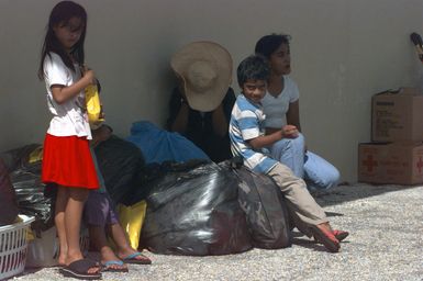 Typhoon victims spend a good part of the day waiting for room assignments at the temporary housing in converted dorms at Andersen Air Force Base south, Guam, after Super Typhoon Paka destroyed or badly damaged their homes