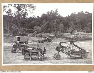 DREGER HARBOUR, NEW GUINEA. 1943-12-06. AN ASSORTMENT OF EQUIPMENT, INCLUDING CARRY-ALL SCOOP, BULLDOZER, BULLDOZER WITH ROOTER AND DRAG LINE, USED BY THE 870TH UNITED STATES AVIATION ENGINEER ..