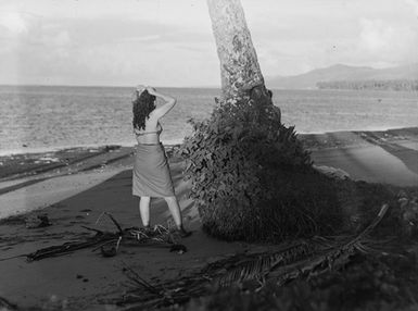 [A Pacific island woman with her back turned looking out to sea]