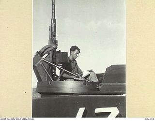 HANSA BAY, NEW GUINEA. 1944-06-17. SERGEANT T. RAFTY, OFFICIAL WAR ARTIST, MILITARY HISTORY SECTION SKETCHING A PICTURE WHILE IN THE GUN TURRET OF A UNITED STATES NAVY TORPEDO BOAT CRUISING ALONG ..