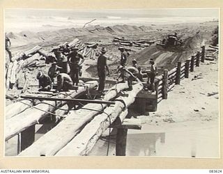 ANAMO AREA, NEW GUINEA. 1944-11-24. 2/2 FIELD COMPANY, ROYAL AUSTRALIAN ENGINEERS, TROOPS VIEWED FROM THE TOP OF A PILE DRIVER WORKING ON A HALF COMPLETED BRIDGE CONSTRUCTED ACROSS AN UNNAMED CREEK ..