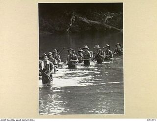 ALEXISHAFEN, NEW GUINEA. 1944-05-16. MEMBERS OF A SECTION FROM NO. 14 PLATOON, C COMPANY, 35TH INFANTRY BATTALION CROSS THE REMPI RIVER WHILE ON PATROL NORTH OF ALEXISHAFEN. IDENTIFIED PERSONNEL ..