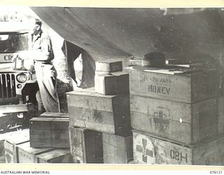 NAGADA, NEW GUINEA. 1944-09-21. DX55 SERGEANT S.J. SAGE, AUSTRALIAN RED CROSS SOCIETY ATTACHED TO HEADQUARTERS 5TH DIVISION ALONGSIDE A JEEP WHICH IS BEING LOADED WITH RED CROSS STORES