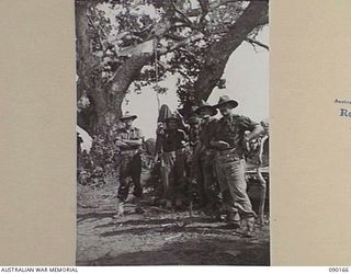 DAGUA, NEW GUINEA. 1945-03-30. MAJ-GEN J.E.S. STEVENS, GOC 6 DIVISION (2), AND CAPT M. DERBYSHIRE, OC A COMPANY (3), POINTING OUT JAPANESE POSITIONS WHICH ARE UNDER BOMBARDMENT. THEY ARE STANDING ..