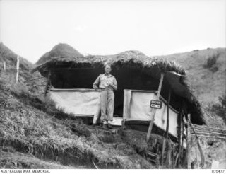 DUMPU, RAMU VALLEY, NEW GUINEA. 1944-02-09. NX231 BRIGADIER F.O. CHILTON, DSO, COMMANDING OFFICER 18TH INFANTRY BRIGADE, PICTURED OUTSIDE HIS HUT ON THE SIDE OF A STEEP SLOPE IN THE FOOTHILLS OF ..