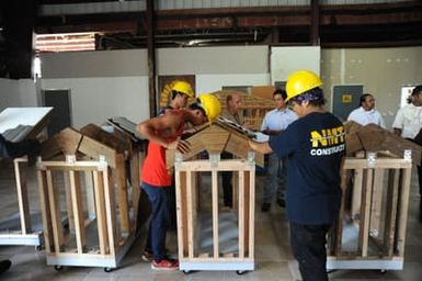 The NMTI students inspecting their models one last time. Their designs ensure the roofs resist the lifting force of winds.