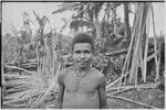 Young man, woven wall panel and other building materials in background