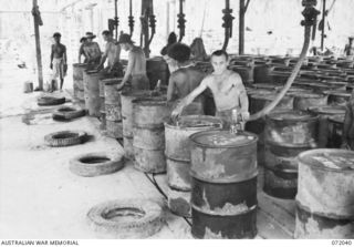 MILNE BAY, NEW GUINEA. 1944-04-04. PERSONNEL OF THE 2ND AUSTRALIAN BULK PETROLEUM STORAGE COMPANY FILLING 44 GALLON DRUMS WITH MOTOR TRANSPORT 80 OCTANE MOTOR SPIRIT