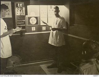 Port Moresby, New Guinea. 1944-05-29. Lieutenant P. B. Stevens (right) assisted by Private R. F. Welladsen, testing a patient's eyesight in the Ophthalmic Department at 128th Australian General ..