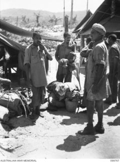 BORAM BEACH, NEW GUINEA, 1945-10-14. ELEVEN INDIAN SOLDIERS WERE LIBERATED FROM THE JAPANESE AT MARIENBERG IN THE SEPIK RIVER AREA. SHOWN, THE MEN AWAITING ADMISSION TO 2/15TH FIELD AMBULANCE