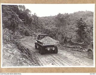 DREGER HARBOUR, NEW GUINEA. 1943-12-03. TRUCKS OF THE 870TH UNITED STATES AVIATION ENGINEER BATTALION CARTING CORAL ROCK TO BE USED IN THE CONSTRUCTION OF THE NEW LANGEMAK BAY-DREGER HARBOUR ROAD