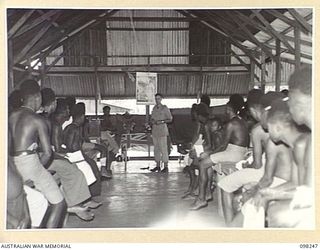 LAE, NEW GUINEA. 1945-10-07. CHAPLAIN K.M. PITHER CONDUCTING A SERVICE IN PIDGIN ENGLISH AT THE AUSTRALIAN NEW GUINEA ADMINISTRATIVE UNIT NATIVE HOSPITAL