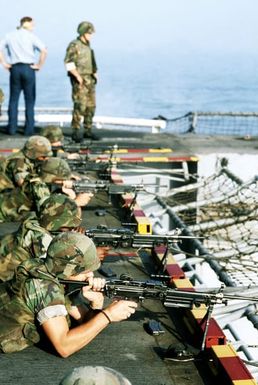 Marines of the 22nd Marine Expeditionary Unit prepare to fire their M-249 squad automatic weapons from the stern of the amphibious assault ship USS SAIPAN (LHA-2) during weapons training held prior Operation Sharp Edge. The SAIPAN is on station off the coast of Liberia