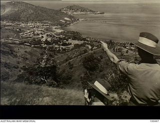 Port Moresby, New Guinea. 1944-05-10. Two Australian soldiers who have climbed Burn's Peak to take photographs and admire the elevated view across the harbour