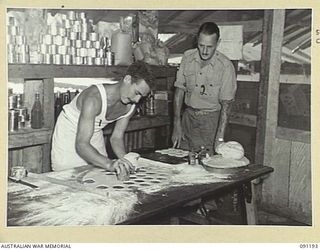 JACQUINOT BAY, NEW BRITAIN. 1945-04-26. PRIVATE E.J. DUPPERS (1), MAKING TARTS AT A SCHOOL IN COOKING CONDUCTED AT 4 FIELD AMBULANCE BY WARRANT OFFICER II GIBBES (2)