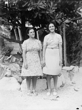 [Full-length portrait of two Polynesian girls in dresses and sandals]