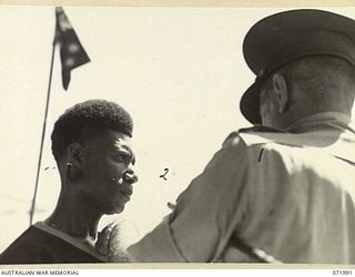 LAE, NEW GUINEA. 1944-04-02. MAJOR GENERAL B.M. MORRIS, DSO, (1), GENERAL OFFICER COMMANDING AUSTRALIAN NEW GUINEA ADMINISTRATIVE UNIT, PRESENTS THE BRITISH EMPIRE MEDAL TO SERGEANT MAJOR ARWESOR, ..