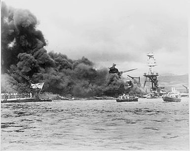 Naval photograph documenting the Japanese attack on Pearl Harbor, Hawaii which initiated US participation in World War II. Navy's caption: Colors flying from USS WEST VIRGINIA(left) and USS ARIZONA (right) aflame, after the Japanese attack on Pearl Harbor of Dec. 7, 1941.