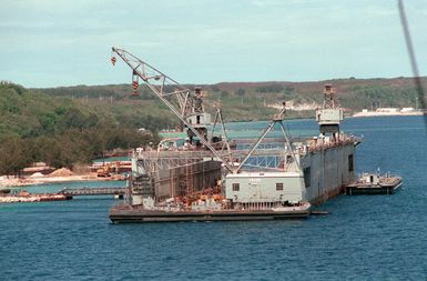 The medium floating dry dock RICHLAND (AFDM-8) is positioned at its new location after being towed from Naval Station, Subic Bay. The floating crane YD-226 is in the foreground