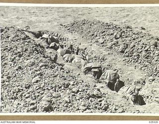 FORBES, NSW. 1943-02. "GUINEA PIGS" TAKING PART IN A GAS SHELL EXPERIMENT HELD BY 2/1 AUSTRALIAN CHEMICAL WARFARE LABORATORY IN A TRENCH IN THE TARGET AREA, PROTECTED BY CAPES