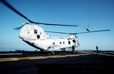 Flight deck crewmen prepare a Marine Medium Helicopter Squadron 261 (HMM-261) CH-46E Sea Knight helicopter for takeoff from the amphibious assault ship USS GUAM (LPH-9)