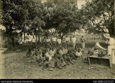 Group of people listening to a graphophone