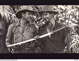 NADZAB, NEW GUINEA. 1943-09-20. NX85058 PRIVATE (PTE) C. L. JOHNSON (LEFT) AND QX18369 PTE S. BLACKMUR OF "C" COMPANY, 2/25TH BATTALION, 25TH AUSTRALIAN INFANTRY BRIGADE DISPLAY A CAPTURED JAPANESE ..