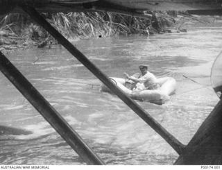 NEW GUINEA, 1942-1943. POSSIBLY WAIROPE RIVER - PROBABLY A NAVY COASTWATCHER GOING ASHORE WITH HIS EQUIPMENT FROM A CATALINA - NOTE THE ROPES USED TO STEADY THE DINGHY AGAINST THE CURRENT. (1 OF 5)