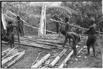 House-building for Rappaports: men with steel axes prepare lumber for frame