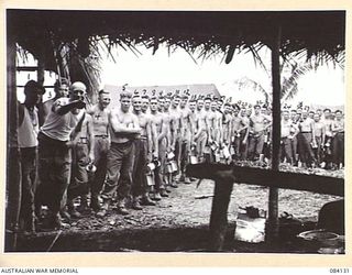 SWAN BEACH, JACQUINOT BAY, NEW BRITAIN. 1944-12-10. 2 FIELD AMBULANCE, AUSTRALIAN ARMY MEDICAL CORPS, 13 INFANTRY BRIGADE ATTENDING A MESS PARADE AT SWAN BEACH