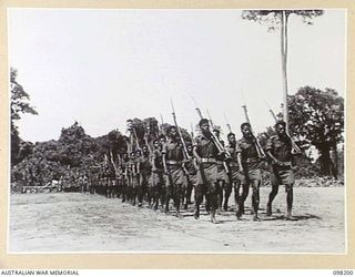 TOROKINA, BOUGAINVILLE. 1945-10-22. A CEREMONIAL PARADE AND MARCH PAST BY PAPUAN INFANTRY BATTALION WAS HELD FOR MAJOR GENERAL W. BRIDGEFORD, GENERAL OFFICER COMMANDING 3 DIVISION. SHOWN, NATIVE ..