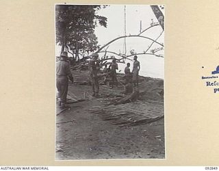 NANTAMBU, NEW BRITAIN, 1945-06. CAPT J. DUNBAR-REID, ASSISTANT DISTRICT OFFICER, NEW BRITAIN (1) AND LT J.H.H. MACGREGOR DOWSETT, ANGAU NATIVE LABOUR (2), CHECK THE WORK OF NATIVES ENGAGED IN ..