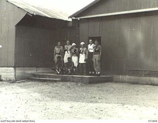 PORT MORESBY, NEW GUINEA. 1944-04-20. PERSONNEL OF THE 6TH FIELD BAKING PLATOON OUTSIDE THE DOOR OF THEIR UNIT BAKERY. THE BAKERY AT PRESENT PRODUCES 77,000 POUNDS OF BREAD PER WEEK. IT IS A ..