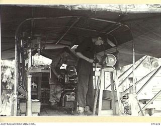 LAE, NEW GUINEA. 1944-03-24. VX65720 CRAFTSMAN E. R. BARTLING (LEFT), WITH VX141818 CORPORAL A. J. DOLDER (RIGHT), OPERATING THE LATHE AND EMERY WHEEL IN THE MOBILE MACHINERY LORRY, 2/125TH BRIGADE ..