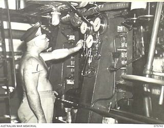 AT SEA. 1944-08/09. LIEUTENANT I. BARTON, RAN, CHIEF ENGINEER OF THE RAN CORVETTE, GEELONG KEEPING A SHARP EYE ON THE PRESSURE GAUGES IN THE ENGINE ROOM AS THE VESSEL PROCEEDS ALONG THE COAST OF ..