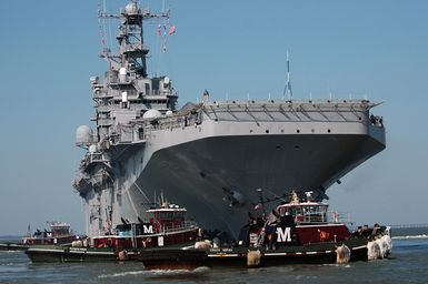 A starboard bow view of the US Navy (USN) Tarawa Class Amphibious Assault Ship, USS SAIPAN (LHA 2), being assisted by commercial tugboats, as it prepares to depart from its homeport at Naval Station (NS) Norfolk, Virginia (VA), to participate in the Multi-National Exercise "PHOENIX EXPRESS" in the Sixth Fleet Area of Responsibility (AOR). The multi-national exercise is focused on developing the individual and collective maritime proficiencies of participating nations. The exercise will promote friendship, mutual understanding and cooperation with regional partners