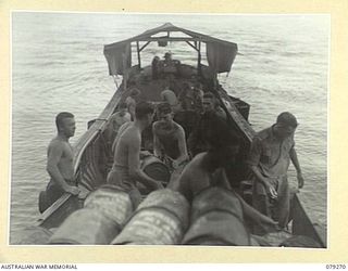 KALAI PLANTATION, NEW BRITAIN. 1945-02-17. PERSONNEL OF THE 19TH INFANTRY BATTALION LOADING STORES ON TO A CAPTURED JAPANESE BARGE NOW USED BY THE 6TH INFANTRY BRIGADE