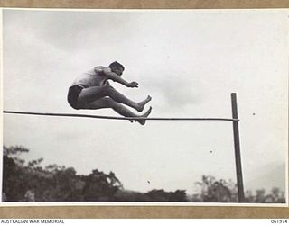 17 MILE, PORT MORESBY AREA, NEW GUINEA. 1943-12-25. PRIVATE MCKENZIE, WINNER OF THE HIGH JUMP, CLEARS 5' 2" AT THE 10TH AUSTRALIAN ADVANCED ORDNANCE DEPOT SPORTS MEETING