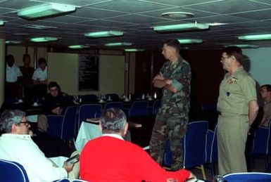 ABOARD USS SAIPAN (LHA-2)....A Navy RADM, right, and a Marine officer brief news correspondents in the wardroom aboard the amphibious assault ship USS SAIPAN (LHA-2) during the joint services exercise Solid Shield '89