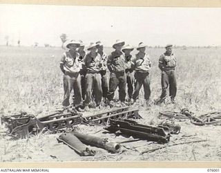 NADZAB AREA, NEW GUINEA. 1944-09-15. PERSONNEL OF THE 2ND MOUNTAIN BATTERY (75MM) STAND BEHIND THE SECTIONS OF THEIR DISMANTLED GUN. IDENTIFIED PERSONNEL ARE:- SERGEANT A.R. DAVIS (1); GUNNER J.W. ..