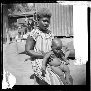 Woman holding a baby in front of her, New Guinea, ca. 1936 / Sarah Chinnery