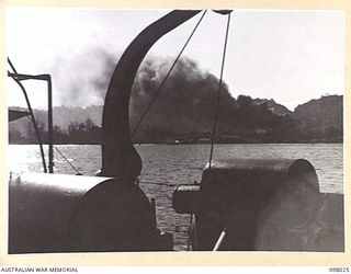 SIMPSON HARBOUR, NEW BRITAIN. 1945-10-13. A LARGE OIL FIRE BURNING ON THE SHORES OF SIMPSON HARBOUR; VIEWED FROM A ROYAL AUSTRALIAN NAVY VESSEL