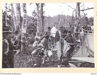 WEWAK AREA, NEW GUINEA, 1945-06-17. TROOPS OF B COMPANY, 2/8 INFANTRY BATTALION AT HILL 1 PACKING THEIR GEAR BEFORE LEAVING FOR THE ATTACK ON HILL 2. IDENTIFIED PERSONNEL ARE:- LT-COL W.S. HOWDEN, ..
