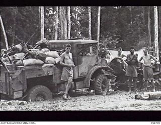 BULLDOG ROAD, NEW GUINEA. 1943-07-09. TRACTOR OF THE COMMAND ROYAL ENGINEERS HITCHED TO BOGGED TRUCK AT THE 1 1/2 MILE POINT