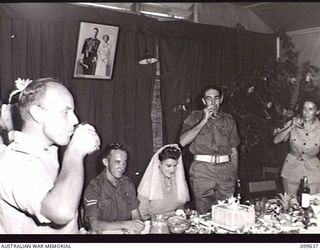 RABAUL, NEW BRITAIN, 1946-01-05. CAPTAIN M. A. STRATTON, OFFICER COMMANDING AUSTRALIAN MOVEMENT CONTROL, PROPOSING THE TOAST TO CORPORAL R. STANLEY, AUSTRALIAN MOVEMENT CONTROL, AND HIS BRIDE, ..